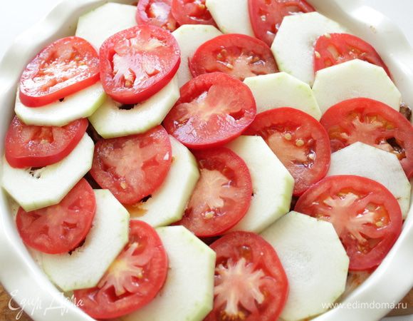 Нарезанные шайбами кабачки и помидоры.