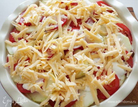 Смазать сметаной, обильно посыпать сыром, отправить в духовку.