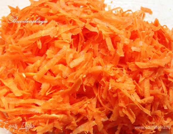 Моем, чистим морковь и натираем на крупной терке, Добавляем в сковороду к луку.
