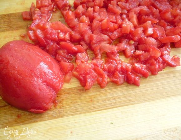 Томаты надрезать крестообразно, ошпарить кипятком, снять кожицу, удалить семена и мелко нарезать.