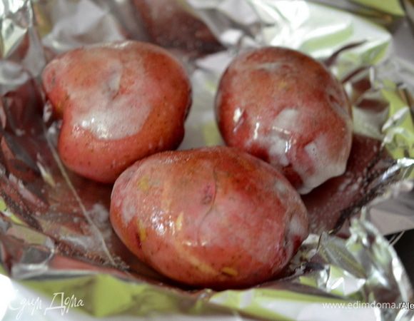 Картофель помыть. 
Выложить на фольгу. Сбрызнуть водой и маслом. Завернуть  и положить на разогретый гриль или в духовку на 200 гр.
Можно делать индивидуальные пакеты для запекания или все в одном.