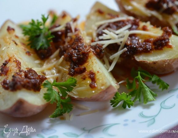 Откроем осторожно пакет. Разрежем картофель и выложим сверху заправку из помидор и сыр Пармезан. Украсим петрушкой и подаем к столу. Подавать по желанию в фольге или без.  Приятного аппетита.
