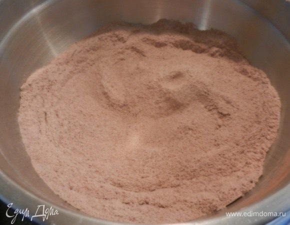 Разогреть духовку до 190 С (375 F). Приготовить 2 высокие формы, смазав маслом. Диаметр форм- 25 см, высота - 5 см. (Т.к у меня были 2 формы меньшим размером- 20,5*3 см , то получилось 3 коржа, а не 2. Ну очень высокий тортик).
Посеять сахар, муку, какао, соду, разрыхлитель и соль.

