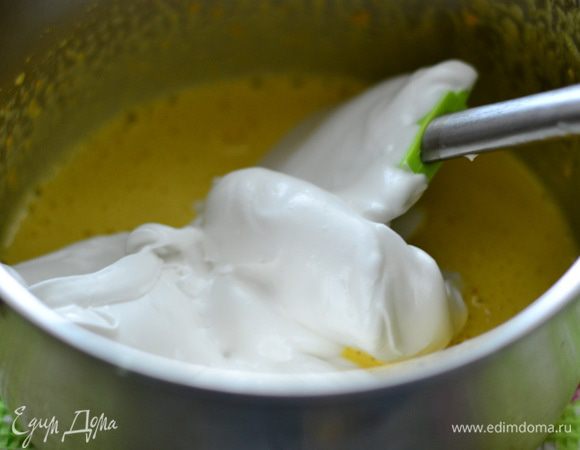 Добавить во взбитые желтки несколько ложек белков, лопаткой аккуратно перемешать.