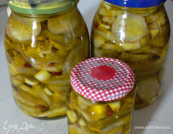 Баклажаны почти сухие, холодные, можно укладывать в стерилизованные и сухие банки. 
На 3 кг мне понадобились 2 литровые банки и две маленькие по 0,350. 
На дно ложим штук 15 кружков баклажанов, сверху примерно 5 кусочков нарезанного  чеснока и примерно 3 огонька. Хорошенько утрамбовываем ложкой. Льем масло, чтобы покрыло. 
И так до верха. Важно, чтобы баклажаны были полностью покрыты маслом. 
Оставляем на ночь без крышек, чтобы вышел воздух. 
Утром доливаем масло до горлышка. Закрываем крышками и в подвал. 
Готово через месяц!  
Хранятся долго. Масло потом можно использовать для приготовления блюд, оно очень ароматное. 
 