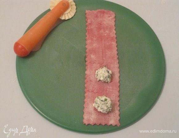  Тесто разделить на небольшие равные части. Раскатать их в тонкие полоски шириной 8 см. Уложить по 1 чайной ложке творожной начинки на расстоянии 3-3,5 см друг от друга.