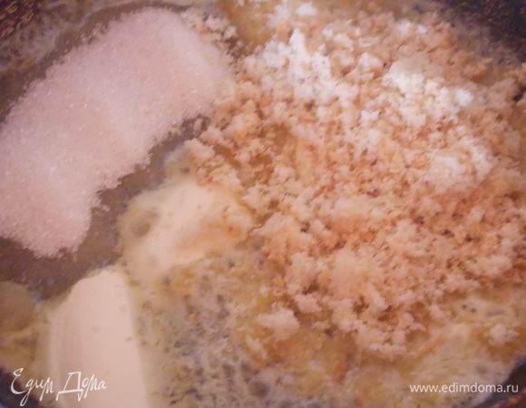 На сковороде разогреть 4 столовые ложки сливочного масла, всыпать туда сахар и добавить крошку.