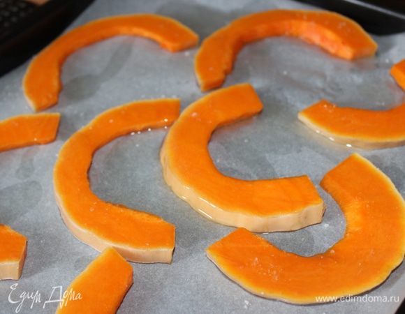 Тыкву нарезать на дольки толщиной 1-1,5 см (молодую тыкву можно не очищать от корки). Выложить дольки на противень, застеленный пергаментом, присыпать солью, сбрызнуть маслом и поставить в духовой шкаф вместе с мясом на 15 минут. Для газовых духовок тыкву необходимо прикрыть пергаментом на 10 минут.