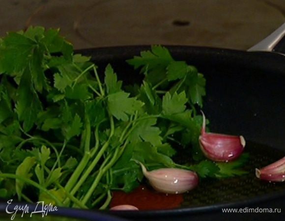 Разогреть в сковороде оливковое масло, добавить зубчики чеснока в кожуре и веточки петрушки.