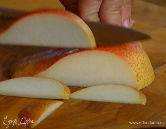 Оставшуюся половинку груши, удалив сердцевину, нарезать очень тонкими дольками и сбрызнуть лимонным соком.