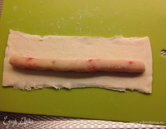 Тесто разделяем, так же на 6 частей.
У меня 7,5 см на 24 см  полоски. На каждую полоску теста выкладываем колбаску из марципана, по сантиметру оставляем с каждой стороны свободные, чтобы можно было хорошо склеить....
