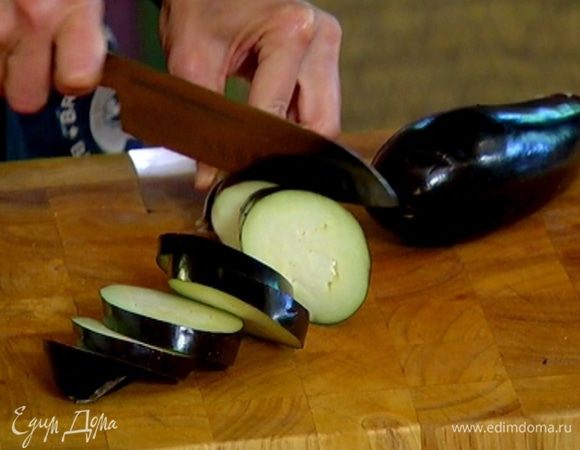 Баклажан нарезать толстыми кружками, выложить в миску, влить 2 ст. ложки оливкового масла и все перемешать.