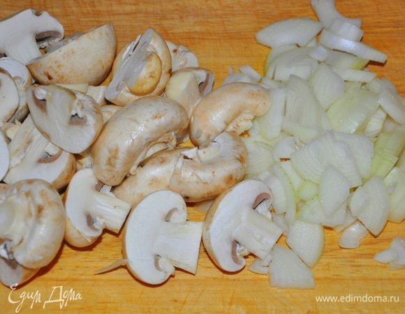 Лук очистить и нарезать дольками, грибы почистить и разрезать пополам. Обжарить все вместе на растительном масле.
