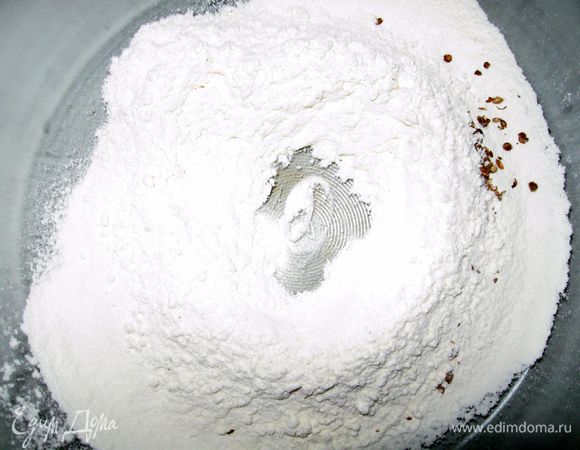 Просеять муку в широкую миску. Добавить соль и все специи. Сделать углубление в центре. Влить молоко, масло и чеснок.