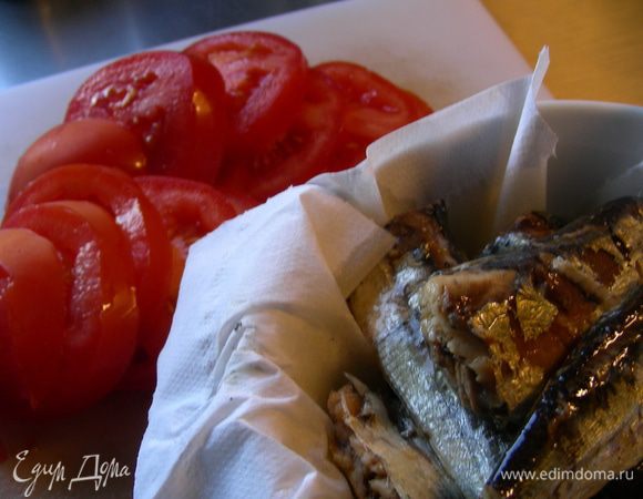 С сардин сливаем масло и обсушиваем их салфеткой. Помидор режем кружочками.
