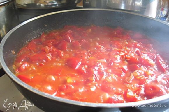 Лук очистить и нарезать кубиками слегка обжарить на сковороде с растительным маслом. Помидоры нарезать крупными кубиками, чеснок - измельчить. На сковороду к обжаренному луку добавить помидоры, чеснок, орегано и сахар, посолить и поперчить по вкусу. Тушить 8-10 минут до размягчения всех овощей.