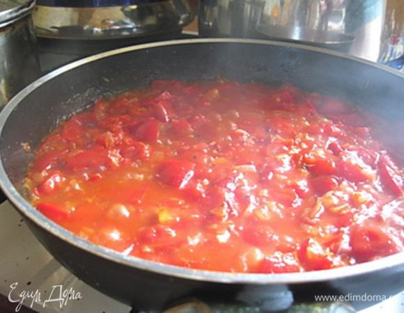 Лук очистить и нарезать кубиками слегка обжарить на сковороде с растительным маслом.
Помидоры нарезать крупными кубиками, чеснок - измельчить.
На сковороду к обжаренному луку добавить помидоры, чеснок, орегано и сахар, посолить и поперчить по вкусу. Тушить 8-10 минут до размягчения всех овощей.