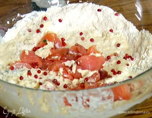 В муку с разрыхлителем влить молочно-сливочную массу, добавить красную рыбу, горошины розового перца и вымешать тесто.