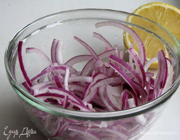Лук нарезать очень тонкими полукольцами, сполоснуть в холодной воде и сбрызнуть лимонным соком.