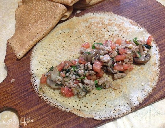 Выложить на блины фарш, скатать рулетами и разрезать по косой на 3 ломтика.