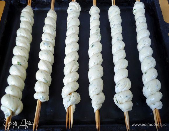 Сложить хлебные спиральки над формой, я кладу на бортики противня так, что бы тесто, не касалось дна. Смазать хлеб желтком, разведенным с двумя столовыми ложками воды. Дать подняться тесту в течение 20 минут.  Выпекать в заранее разогретой духовке до 180-200 градусов, примерно 30 минут. Во время выпечки надо перевернуть один-два раза, что бы хлебушек подрумянился со всех сторон.