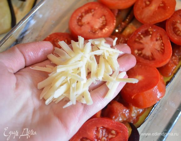 Сверху выкладываем кружочки томатов и посыпаем все тертым сыром