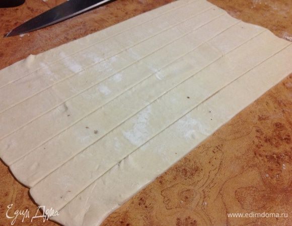 Слоеное раскатать,и нарезать полосками шириной в два сантиметра.