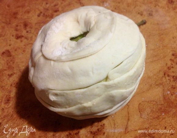 Яблоко обмакнуть в сахаре и плотно обмотать полосками тестом. Дно тоже должно быть полностью закрыто тестом.