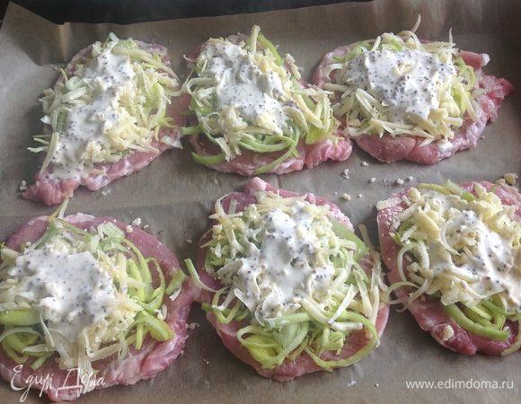 Свиные медальоны положить на противень ,поперчить ,посолить...
Лук нарезать крупно,кольцами ....распределить на все медальоны....
Сыр натереть на крупной терке.....так же распределить сверху лука....

