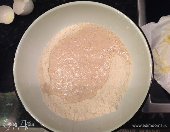 Делаем в центре углубление, затем вливаем нашу дрожжевую массу и перемешиваем до получения мягкого теста. Вымешиваем тесто на просыпанной мукой поверхности, кладем в миску, накрываем крышкой и в тепло, пока тесто не увеличится в объеме вдвое.