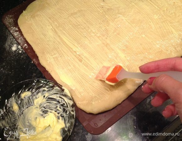 Как только тесто подошло, вымешиваем его до эластичного состояния и раскатываем в квадрат (сторона 23-25 см). Намазываем оставшимся маслом (предварительно немного растопив).