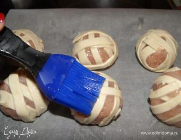 Выложить клубочки на противень, застленный бумалой для выпечки, смазанной растительным маслом. Клубочки смазать взбитым яйцом.