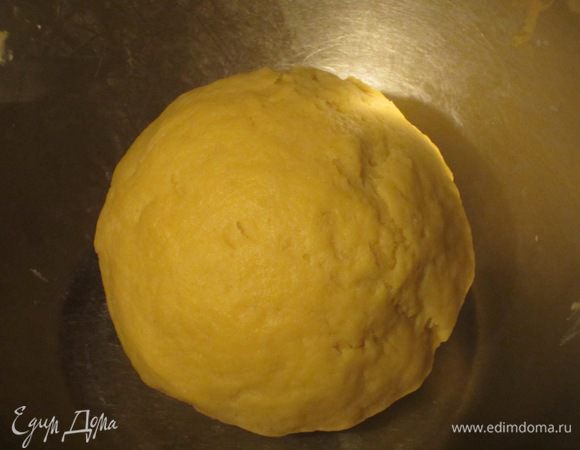Добавить желтки, 50 мл воды и замесить однородное тесто. Сформировать шар, завернуть в пищевую плёнку и отправить в холодильник на 30 минут.