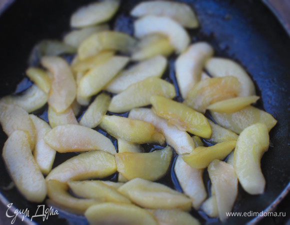 Снять крышку, увеличить огонь и карамелизировать яблоки до золотистого цвета. Влить ром и готовить ещё несколько минут до выпаривания алкоголя.
