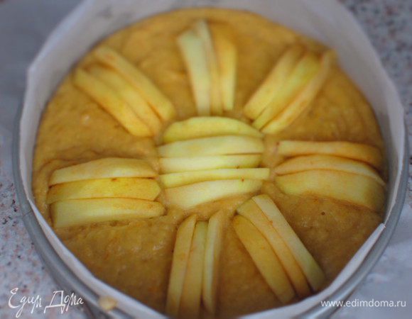 Вылить тесто в форму с пергаментом и сверху выложить оставшуюся часть яблок. Выпекать в разогретой до 180°С духовке 50 минут.