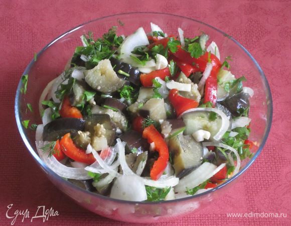 Сложить в большую емкость нарезанные баклажаны, чеснок, лук, перец, зелень, горький перец.