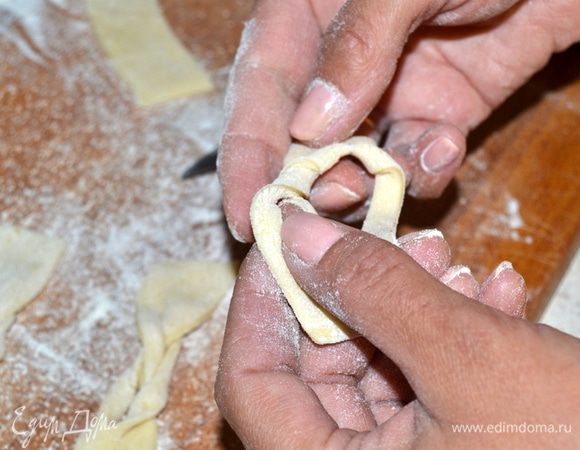 Затем через вторую дырочку другой конец и растягиваем в стороны немного.