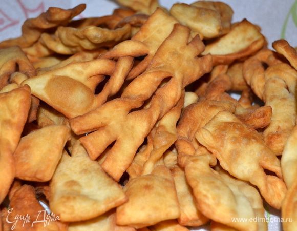 Подрумяненный хворост вытаскиваем шумовкой и выкладываем на бумажное полотенце, чтобы удалить излишки масла.