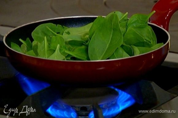 Разогреть в сковороде 1 ст. ложку оливкового масла и припустить шпинат на медленном огне.