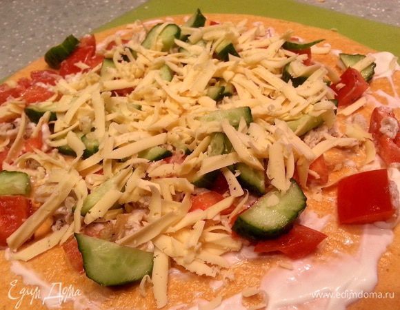 Помыть и нарезать кубиками болгарский перец. Обжарить перец на оливковом масле, взбить яйцо и вылить на сковородку. Лопаточкой аккуратно помешивать содержимое на сковороде. После того как яйцо немного схватится, довести до состояния "яйцо в крошку". Посолить, поперчить. Взять одну лепешку, смазать ее полностью творожным сыром, выложить на нее яйцо с перцем, добавить нарезанный огурец и натертый на терке твердый и плавленый сыр.
