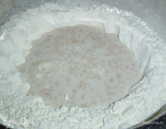 В теплое молоко помещаем раскрошенные дрожжи и чайную ложечку сахара, даем немного постоять, чтобы дрожжи "ожили". Муку просеиваем в миску, делаем углубление и в него выливаем молочно-дрожжевую смесь, припыляем мукой, накрываем полотенцем и даем постоять около получаса.