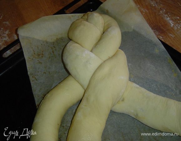 Противень застилаем пергаментом, на него кладем рядышком три рулета, с одной стороны все их скрепляем вместе и плетем косу, 