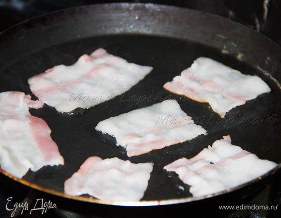 Ломтики бекона разрезать на 3-4 части и выложить на хорошо разогретую сковороду. Обжарить до хруста с обеих сторон. 