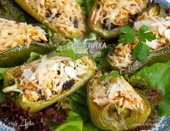 Готовые перцы выкладываем на листья салата. Сверху слегка сбрызгиваем оливковым маслом, присыпаем миндальными лепестками и тёртым сыром. Украшаем петрушкой.