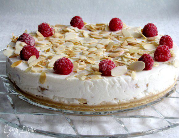 Когда торт застынет, осторожно вынимаем его из формы и украшаем по своему желанию фруктами и орехами. Я украсила слегка обжаренными миндальными лепестками и малиной.