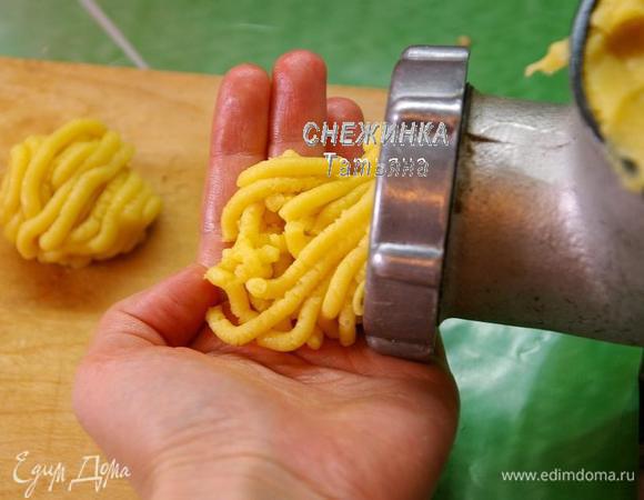 Теперь подготовим основной инструмент – мясорубку. Кладём в неё часть теста. В процессе выхода теста из мясорубки формируем печенье. Можно придавать ему любую форму, мне нравится круглой, с рисунком тоже можно «играть», по-разному оформляя выходящие «макарошки». Печенье лепим до того момента, пока тесто не закончится.