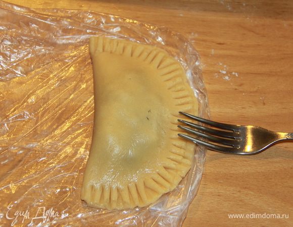 Складываем круг пополам, прижимаем края вилкой.