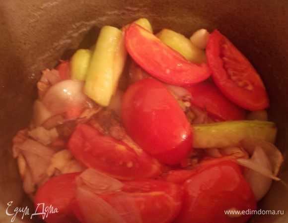 Затем добавляем помидоры, кабачок и раздавленный чеснок, на сильном огне обжариваем, чтобы выкипел весь сок.