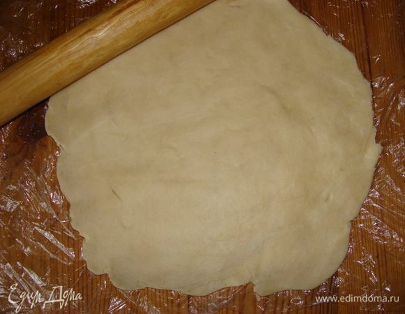 Достать тесто из холодильника, раскатать скалкой до 5 мм толщиной. Переложить в форму, смазанную растительным маслом. Края слегка придавить к бортикам формы, сформировав этим некое подобие тарелочки.