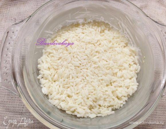 Форму для запекания смазать сливочным маслом и выложить рис. Разровнять.
